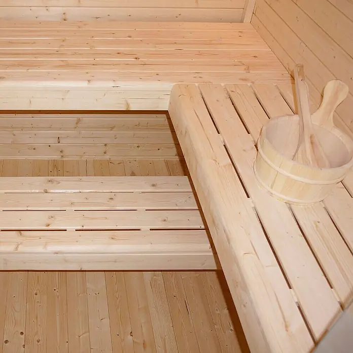 Home Deluxe Fasssauna TALO XL - Elektroofen, Holz - Sauna-Innenraum mit hellen Holzbänken, passendem Holzeimer und Schöpfkelle.