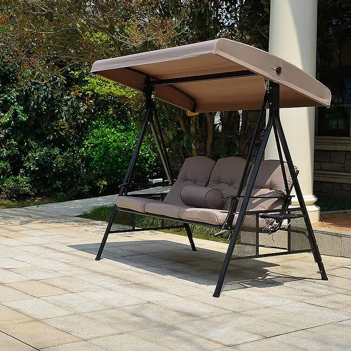 Home Deluxe Garten-Schaukelstuhl Hollywoodschaukel DESCANSO inkl. Regenabdeckung - Beige, B x T x H: 115 x 198 x 195 cm - Braune Zweisitzer-Gartenschaukel mit dunklem Metallrahmen und Verdeck auf einer Terrasse.