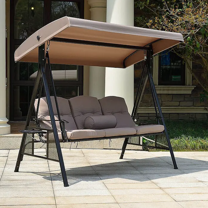 Home Deluxe Garten-Schaukelstuhl Hollywoodschaukel DESCANSO inkl. Regenabdeckung - Beige, B x T x H: 115 x 198 x 195 cm - Dreisitzige Gartenschaukel mit schwarzem Metallrahmen, beigem Vordach und taupefarbenen Kissen auf einer Terrasse.