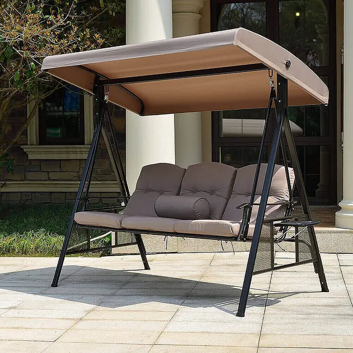 Home Deluxe Garten-Schaukelstuhl Hollywoodschaukel DESCANSO - Beige, B x T x H: 115 x 198 x 195 cm - Dreisitzer-Gartenschaukel mit dunklem Metallrahmen, beigem Vordach und gepolsterten Kissen, auf einer Terrasse.