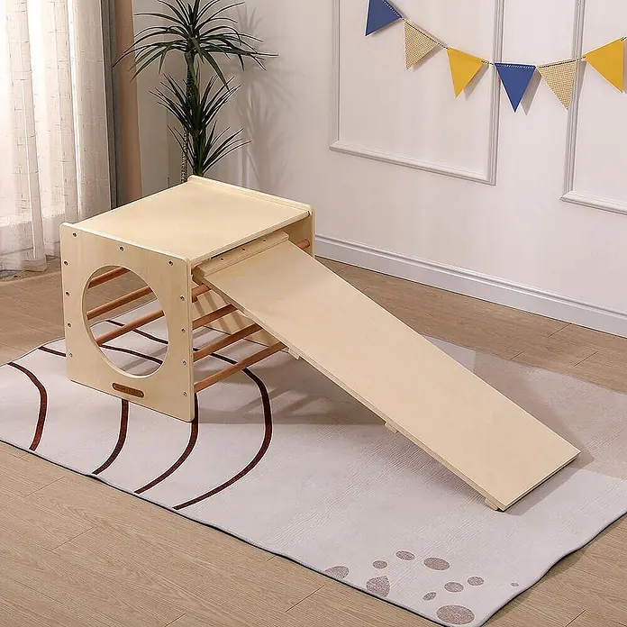 Home Deluxe Klettergerüst FINN - Holz, Natur - Heller Spielwürfel aus Holz mit Klettersprossen und einer Rutschrampe, auf einem Teppich in einem Raum.