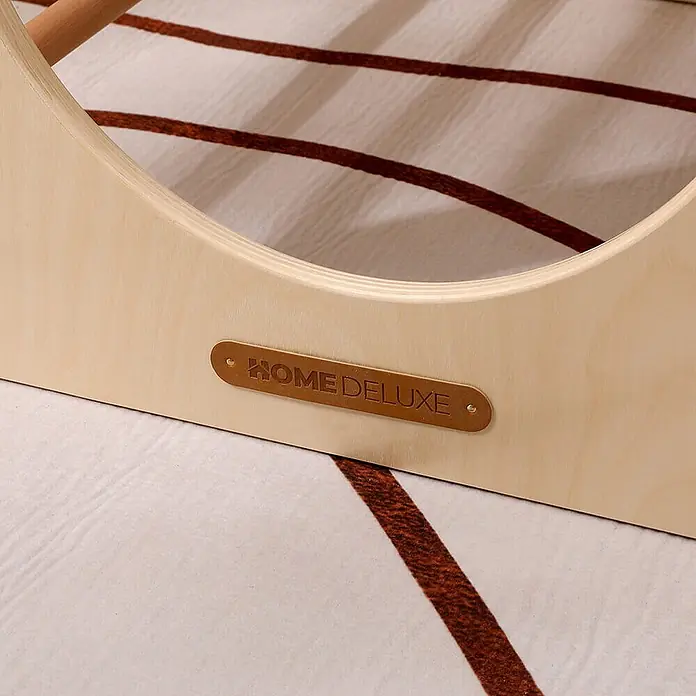 Home Deluxe Klettergerüst FINN - Holz, Natur - Helles, gebogenes Holzgestell mit braunem 'HOME DELUXE'-Lederetikett, auf einem gemusterten Teppich.