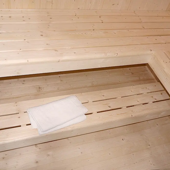 Home Deluxe Elementsauna SHADOW BIG XL - Elektroofen, Steuerung Ofen: Integriert, L x B x H: 200 x 200 x 190 cm - Weißes gefaltetes Handtuch auf einer hellen Saunabank aus Holz.