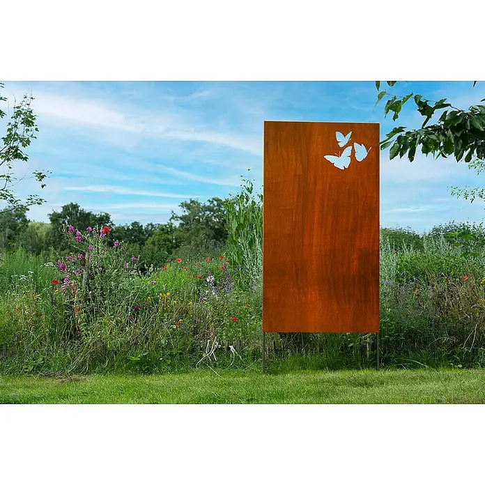 Home Deluxe Sichtschutzelement BUTTERFLY - Stahl, Orange - Rostige Gartensäule aus Metall mit Schmetterlingsausschnitten, inmitten von Wildblumen und Gras.