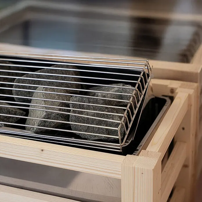 Home Deluxe Elementsauna SHADOW BIG XL - Elektroofen, Steuerung Ofen: Integriert, L x B x H: 200 x 200 x 190 cm - Saunaofen mit grauen Steinen in einem Metallgitter, umrahmt von hellem Holz.