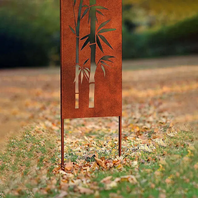 Home Deluxe Sichtschutzelement AURELIA - Stahl, Orange - Gartenstecker aus Cortenstahl mit Bambusmotiv, in einem Garten mit Gras und Herbstblättern.