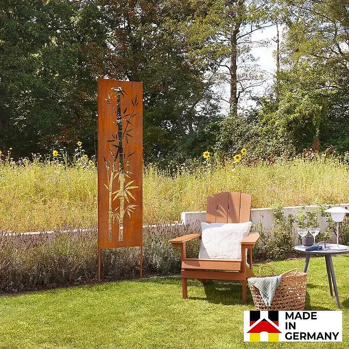 Home Deluxe Sichtschutzelement AURELIA - Stahl, Orange - Rostfarbener Metall-Gartenschirm mit Bambus-Ausschnitten, im Garten stehend.