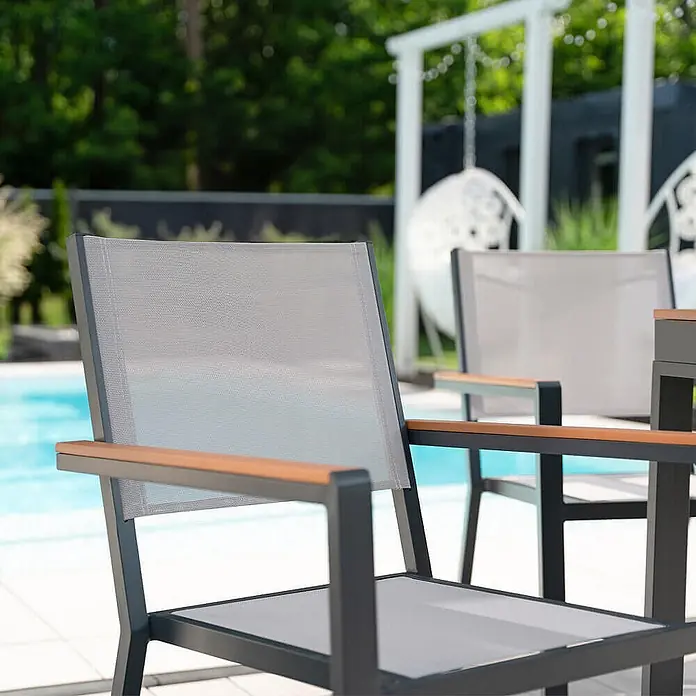 Home Deluxe Gartentisch-Set CANTOS SEDIA -  - Gartenstuhl mit dunkelgrauem Gestell, hellgrauem Netzgewebe und Holzarmlehnen, am Pool.
