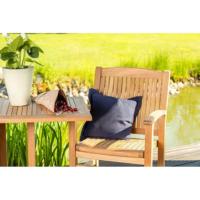 Kai Wiechmann Sitzauflage - Marineblau - Outdoor-Beistelltisch und Sessel aus Holz mit blauem Kissen.