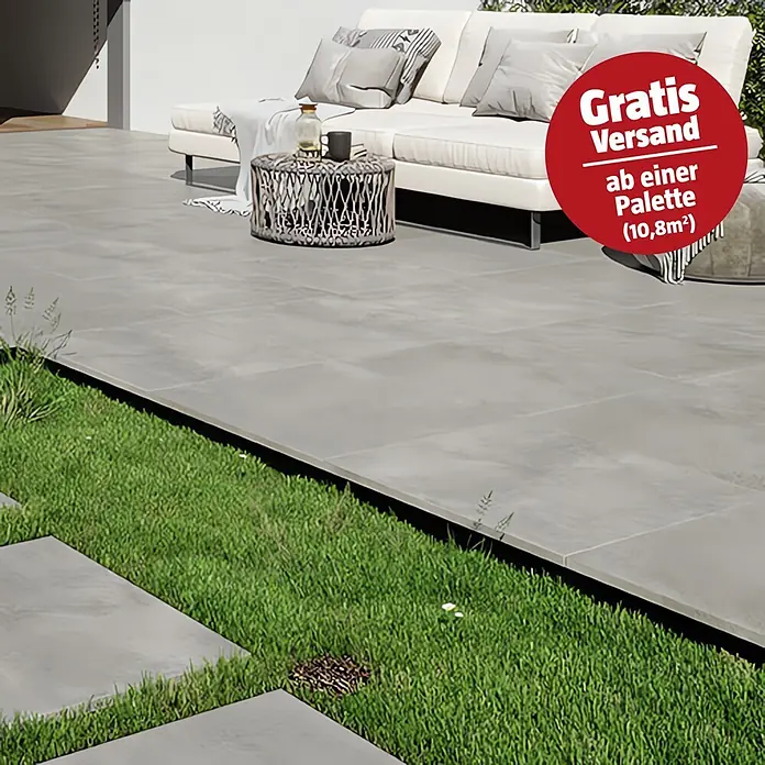 Queens Terrassenfliese - 59,3 x 59,3 x 2 cm, Grau, Matt - Graue Terrassenfliesen bilden einen modernen Außenbereich neben einer Rasenfläche.