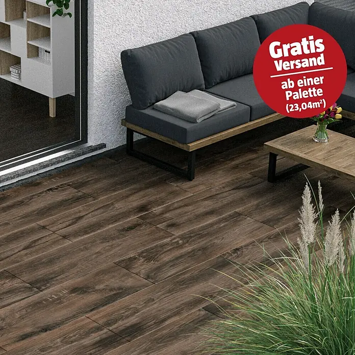 Marazzi Terrassenfliese Esterno 20T Trevermade - 40 x 120 x 2 cm, Zeder, Matt - Dunkelbraune Holzoptik-Bodenfliesen diagonal auf einer Außenterrasse mit Möbeln verlegt.