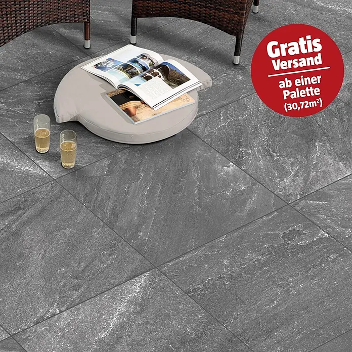 Terrassenfliese Cera 2.0 - 80 x 80 x 2 cm, Quarz Nero, Matt - Dunkelgraue Steinfliesen auf einer Terrasse mit Sitzmöbeln.
