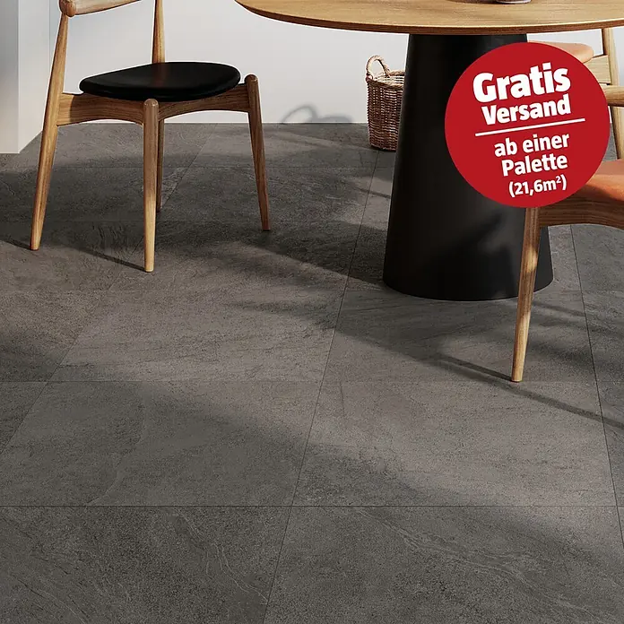 Atlas Concorde Solution Terrassenfliese Island Black - 60 x 60 x 2 cm, Schwarz, Matt - Dunkelgraue Fliesen in Steinoptik, verlegt in einem Essbereich mit Holztisch und Stühlen.