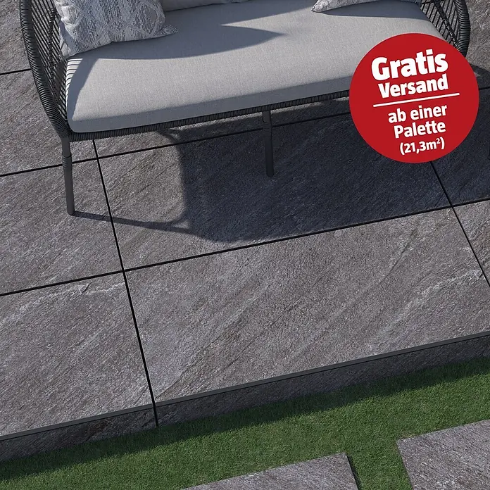 Terrassenfliese Piazza 2.0 - 59,7 x 119,7 x 2 cm, Anthrazit, Matt - Strukturierte dunkelgraue Terrassenplatten mit dunklen Fugen, bilden einen Außenbereich mit moderner Gartenbank.