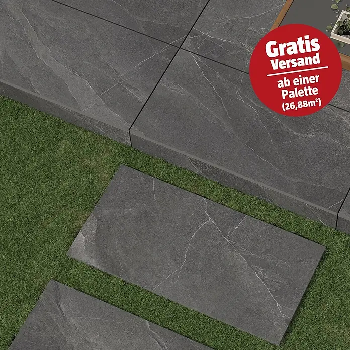 Terrassenfliese Monte 2.0 - 39,7 x 79,7 x 2 cm, Anthrazit, Matt - Dunkelgraue Terrassenplatten in Steinoptik mit weißen Äderungen, als Terrasse und Trittsteine im Gras verlegt.