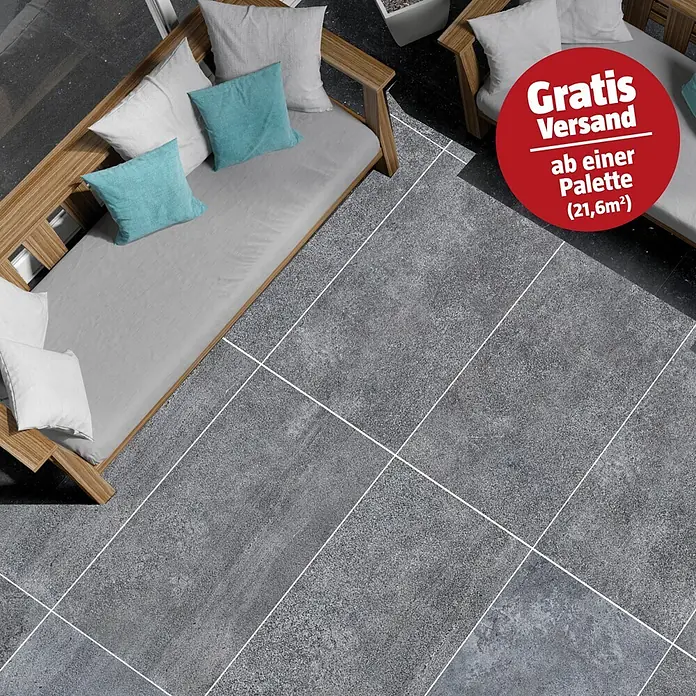 RAK Ceramics Terrassenfliese Opificio 2.0 - 60 x 120 x 2 cm, Grau, Matt - Graue, texturierte Terrassenfliesen mit weißen Fugen unter Holzgartenmöbeln.