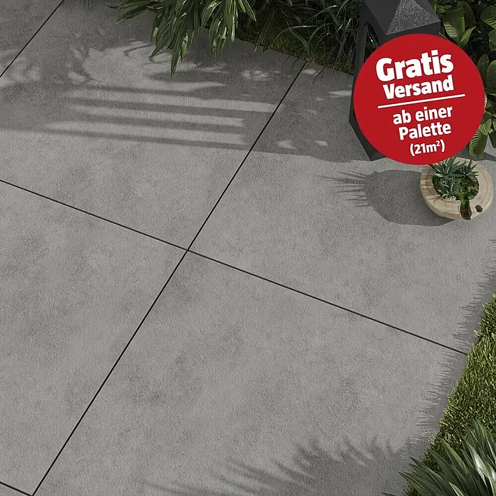 Cersanit Terrassenfliese Metropolis - 59,3 x 59,3 x 2 cm, Grey, Matt - Texturierte graue Outdoor-Pflasterplatten mit dunklen Fugen, in einer Gartenumgebung verlegt. Ein roter Kreis bewirbt 'Gratis Versand!' ab einer Palette (21m²).
