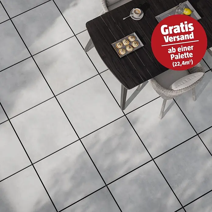 Terrassenfliese Dimension - 59,7 x 59,7 x 2 cm, Grau, Matt - Graue quadratische Terrassenfliesen mit dunklen Fugen, Teil eines Essbereichs im Freien.