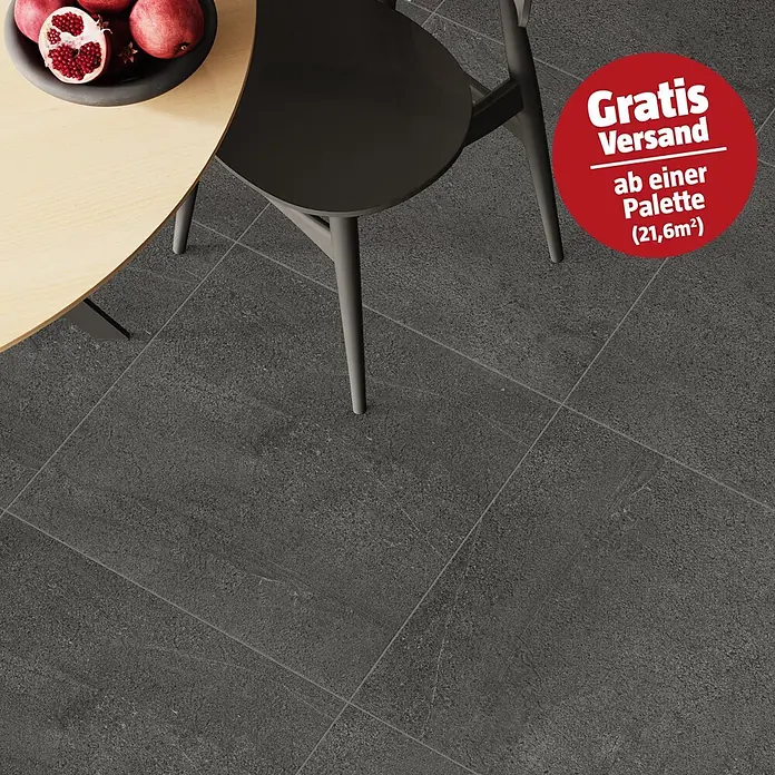Terrassenfliese Patio - 60 x 60 x 2 cm, Anthrazit, Matt - Dunkelgraue Bodenfliesen mit einer strukturierten, steinähnlichen Oberfläche in einem modernen Raumambiente.