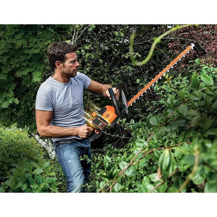 Worx PowerShare 20V Akku-Heckenschere WG284E.9 - 40 V, Ohne Akku - Ein Mann benutzt eine orangefarbene Heckenschere zum Beschneiden von Büschen.