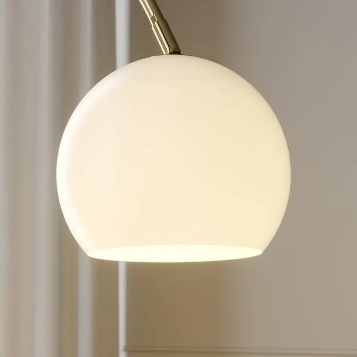 Lindby Stehleuchte Cynthia - Höhe: 140 cm, messing / gold, E27 - Eine kugelförmige, leuchtende weiße Glaslampenabdeckung an einem goldfarbenen Metallarm.