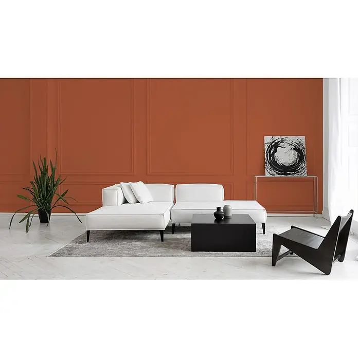 Livingwalls Wandfarbe Rot, Dusty Orange DD126158 2,5l - Orange, Matt, 2,5 l - Ein modernes weißes Ecksofa mit schwarzem Couchtisch in einem Wohnzimmer mit oranger Akzentwand.