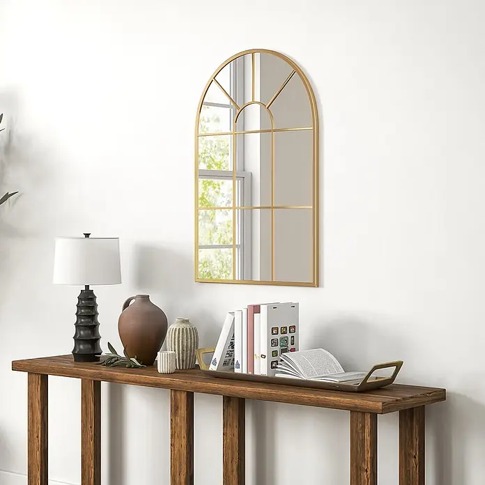 Homcom Wandspiegel - 2 x 91 cm, Gold - Goldener Bogenspiegel mit Gitterdetails, der ein Fenster mit Grün reflektiert, über einem Holzkonsolentisch mit Dekoartikeln.