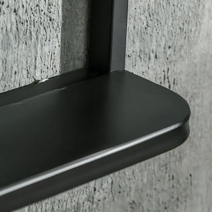 Homcom Wandspiegel - 10,2 x 70 cm, Schwarz - Nahaufnahme eines schwarzen Metallregals an einer strukturierten grauen Betonwand.
