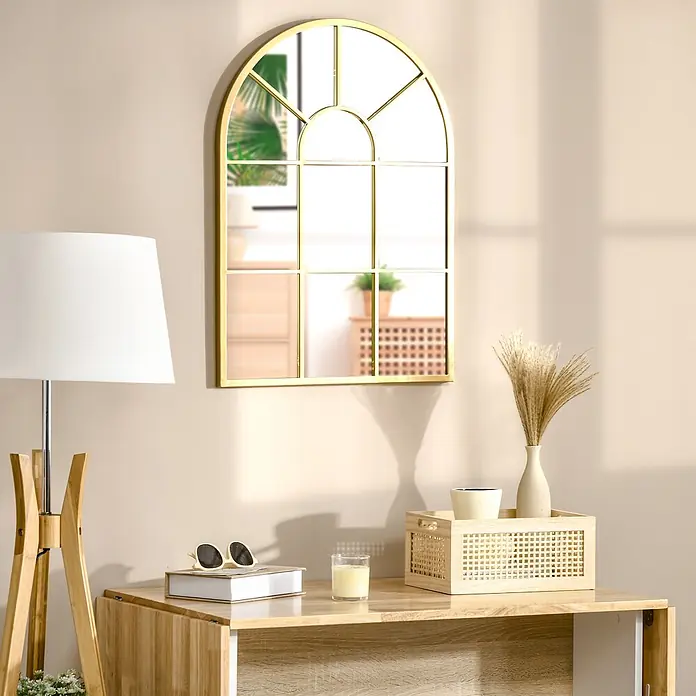 Homcom Wandspiegel - Gold - Goldgerahmter Bogen-Spiegel mit Gitterdesign, über einem Holztisch hängend. Er reflektiert Pflanzen und Möbel, was dem Raum Tiefe verleiht.