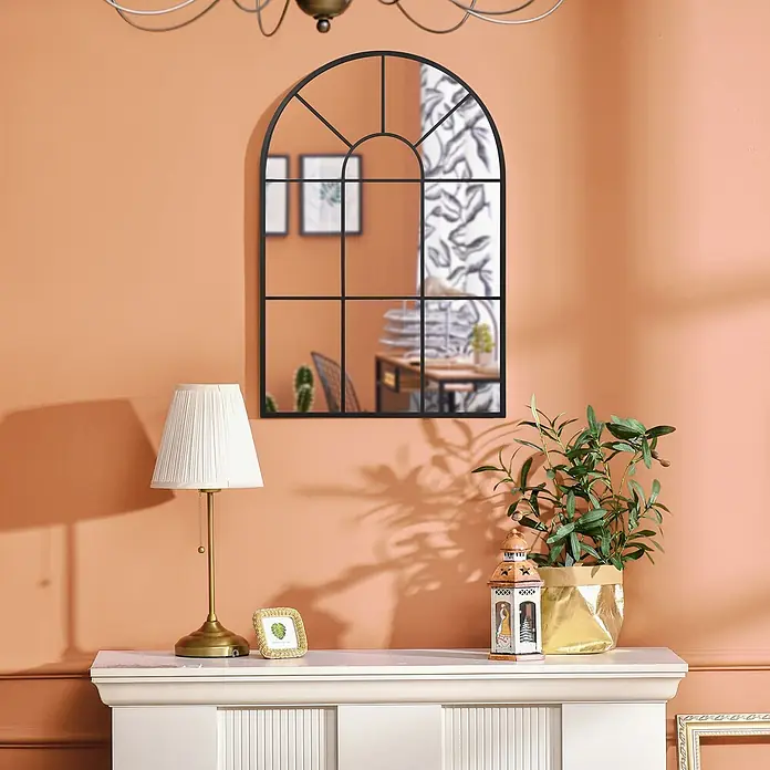 Homcom Wandspiegel - 2 x 91 cm, Schwarz - Gewölbter schwarzer Metallspiegel mit Gittermuster, an einer pfirsichfarbenen Wand über einem Kaminsims hängend, der einen Raum reflektiert.