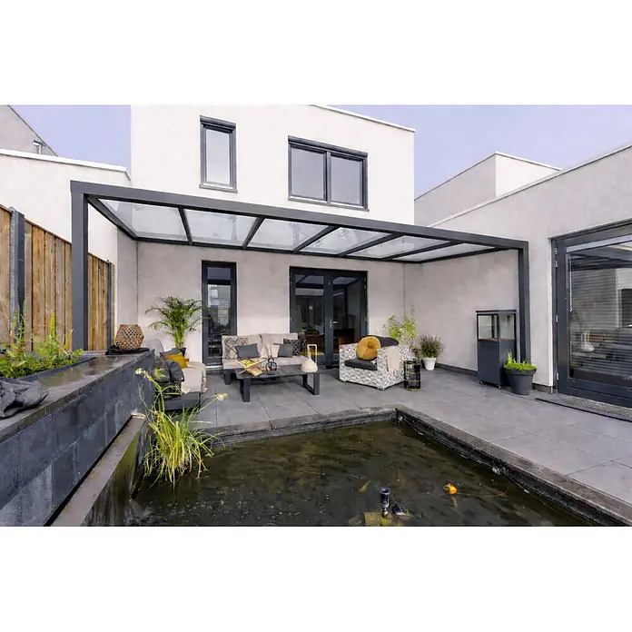 Gardendreams Terrassenüberdachung Essence - B x T: 300 x 255,5 cm, Anthrazitgrau, Verbundsicherheitsglas (VSG), Klar - Moderne Pergola mit schwarzem Rahmen und Klarglasdach, schützt einen stilvollen Terrassen-Wohnbereich neben einem modernen Haus.