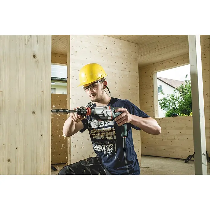 Metabo Kombihammer KHE 2860 - 880 W, 3,2 J, SDS-Plus-Aufnahme - Arbeiter bohrt mit einem Metabo Bohrhammer in eine Holzwand, trägt Schutzkleidung.