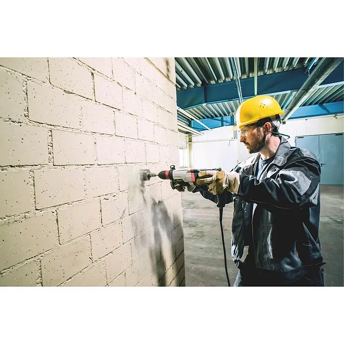 Metabo Kombihammer KHE 2860 - 880 W, 3,2 J, SDS-Plus-Aufnahme - Person bohrt mit einem grau-roten Bohrhammer und Kernbohrer in eine helle Ziegelwand.