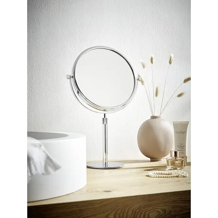 Calmwaters Kosmetikspiegel - Durchmesser: 15,3 cm, Rund, Chrom, Vergrößerung 1: 300 % - Verchromter Stand-Schminkspiegel auf einem Waschtisch aus Holz, umgeben von Kosmetikprodukten und Trockenblumen.