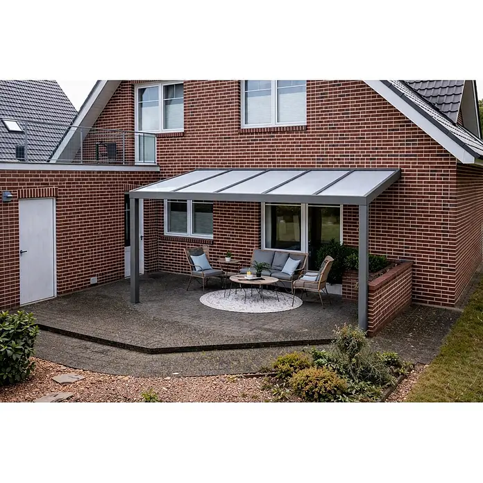 Gardendreams Terrassenüberdachung Elegance - B x T: 400 x 355,5 cm, Graualuminium, Polycarbonat, Opal - Graue Terrassenüberdachung mit transluzenten Dachplatten über einem möblierten Backsteinhaus-Patio.