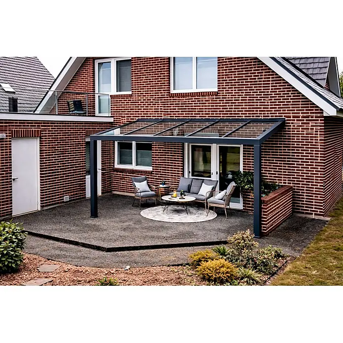 Gardendreams Terrassenüberdachung Elegance - B x T: 400 x 305,5 cm, Anthrazitgrau, Verbundsicherheitsglas (VSG), Klar - Dunkelgrau gerahmte Glas-Terrassenüberdachung über einem Sitzbereich im Freien neben einem Backsteinhaus.
