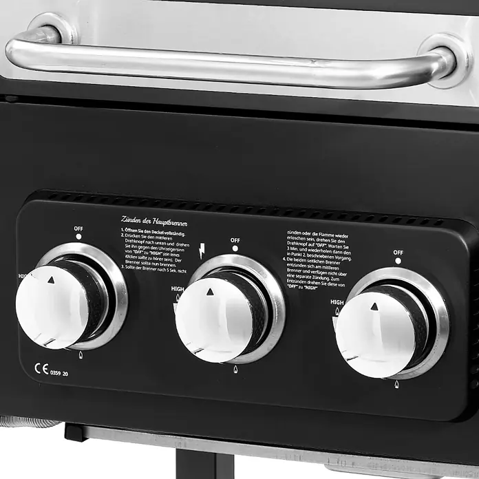 TAINO Holzkohlegrill HERO DUO - Schwarz - Schwarzes Gasgrill-Bedienfeld mit drei Chromknöpfen und deutschen Anweisungen zum Zünden der Hauptbrenner.