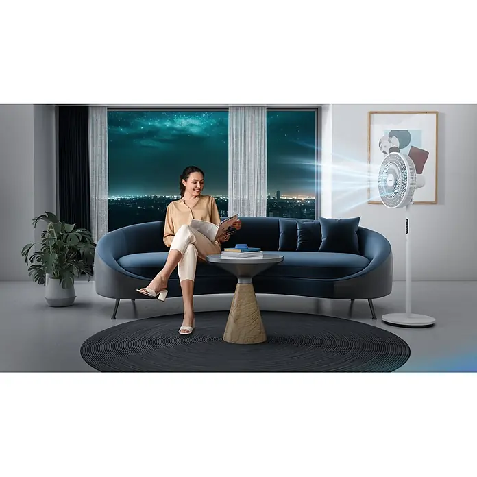 Midea Standventilator MFS352RDDW - Weiß, 40 cm, 130 cm - Weißer Standventilator in modernem Wohnzimmer, kühlt eine Frau, die nachts auf einem Sofa liest.