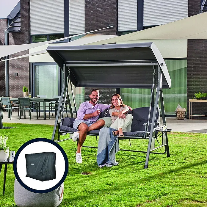 Home Deluxe Garten-Schaukelstuhl Hollywoodschaukel DESCANSO inkl. Regenabdeckung - Grau - Dunkelgraue Gartenschaukel mit Dach, von zwei Personen genutzt. Eine Schutzhülle ist ebenfalls abgebildet.