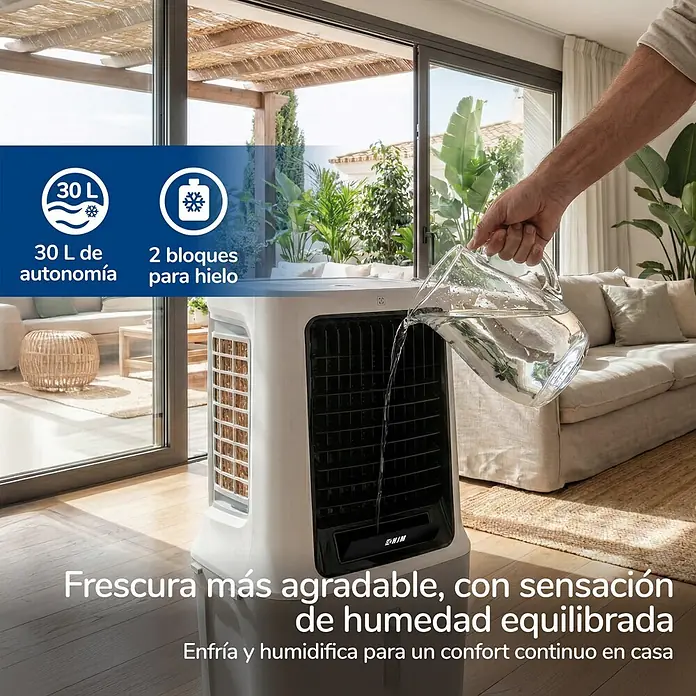 HJM Climatizador evaporativo CLIM512 - 120 W, Altura: 87 cm, Blanco, 30 litros - Un enfriador de aire evaporativo blanco siendo llenado con agua en una sala de estar luminosa, ofreciendo humedad equilibrada y frescura.
