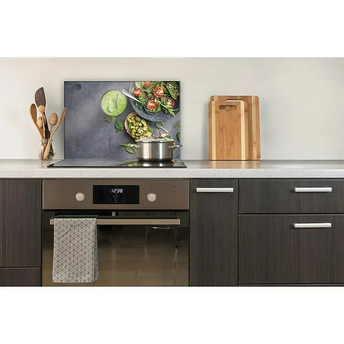 CUCINE Küchenrückwand - Fresh Avocado, 60 x 40 cm, Stärke: 6 mm, Einscheibensicherheitsglas (ESG) - Küchenansicht mit einem Kochfeld mit einem Topf darauf und einem Spritzschutz mit Essensmotiven hinter dem Kochfeld.