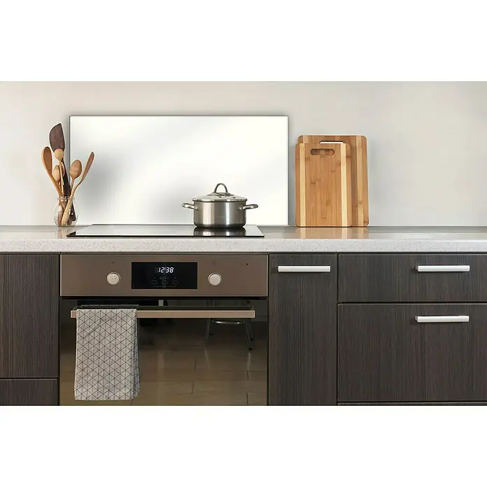 CUCINE Küchenrückwand - Weiß, 80 x 40 cm, Stärke: 6 mm, Einscheibensicherheitsglas (ESG) - Ein moderner Küchenherd mit Kochfeld und Ofen in Edelstahl-Optik. Ein Geschirrtuch hängt am Griff.