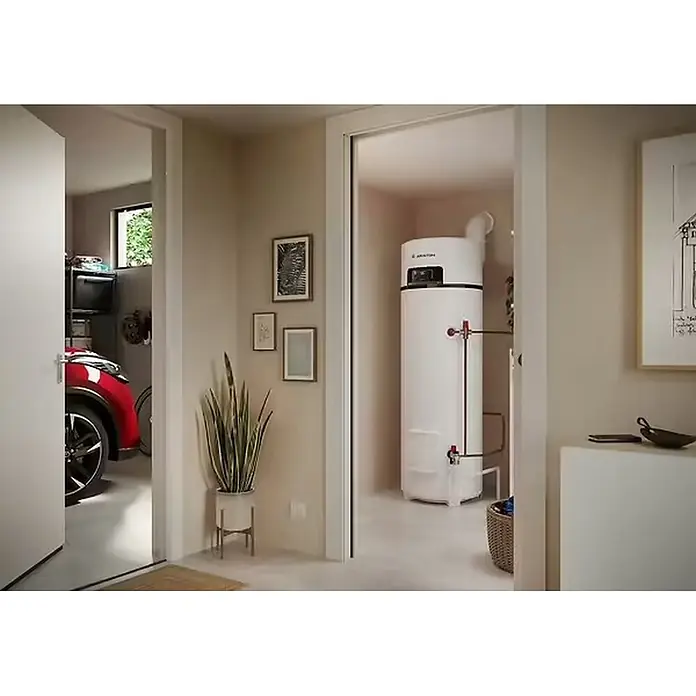 Ariston Bomba de calor Nuos Fit S2 Wifi - 250 l, 1.800 W - Un calentador de agua blanco alto instalado en un cuarto de servicio, visible a través de una puerta.