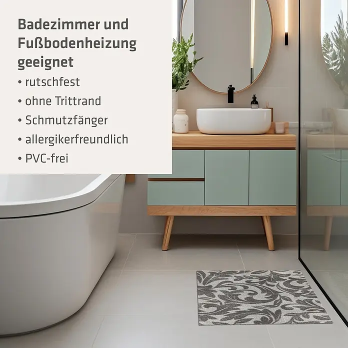 Akzente Fußmatte Feel - Mehrfarbig, Motiv / Muster|Floral - Ein grau-weiß gemusterter Badteppich liegt auf hellen Fliesen in einem modernen Badezimmer mit Waschtisch und Badewanne.