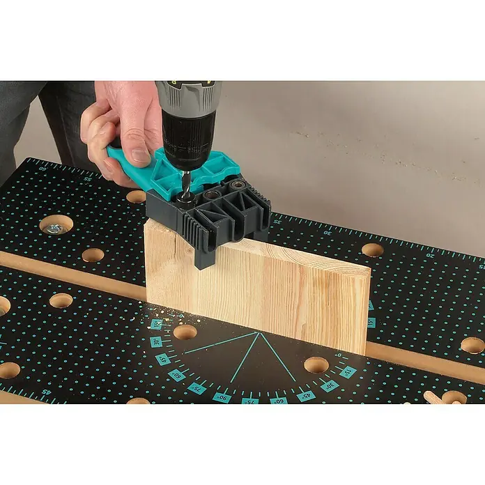 Wolfcraft Guía para espigas - Plástico, Topes integrados - Un carpintero utiliza un taladro y una plantilla de perforación para hacer un agujero en una pieza de madera.