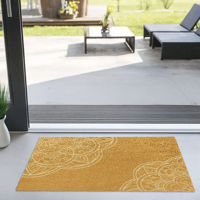 Akzente Fußmatte Feel - Mehrfarbig, Motiv / Muster - Goldene Fußmatte mit weißem Mandala-Muster am Eingang einer sonnigen Terrasse.