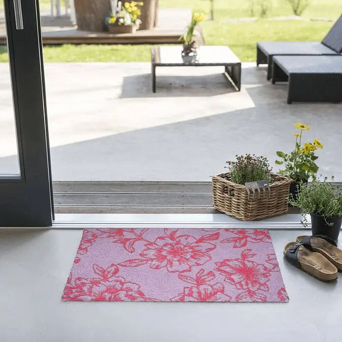 Akzente Fußmatte Feel - Mehrfarbig, Motiv / Muster - Rechteckige lavendelfarbene Fußmatte mit rotem Blumenmuster, platziert am Eingang einer Terrasse.