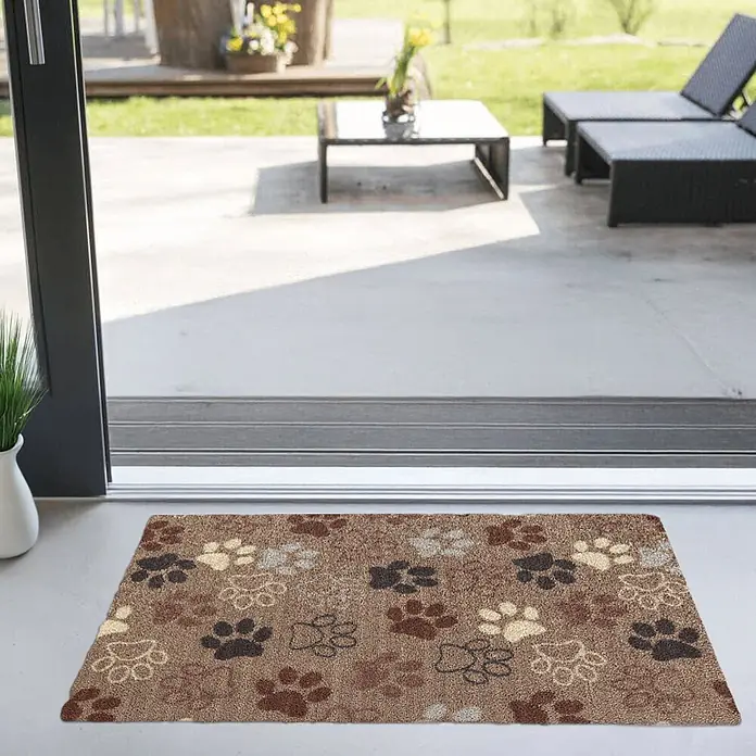 Akzente Fußmatte Feel - Mehrfarbig, Motiv / Muster|Tiere - Braune Fußmatte mit bunten Pfotenabdrücken, platziert am Eingang einer Glastür zur Terrasse.