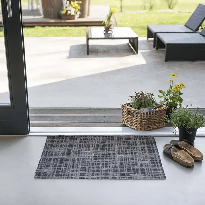 Akzente Fußmatte Feel - Mehrfarbig, Motiv / Muster - Dunkelgraue Fußmatte mit hellgrauem, abstraktem Gittermuster, an einem Terrasseneingang platziert.