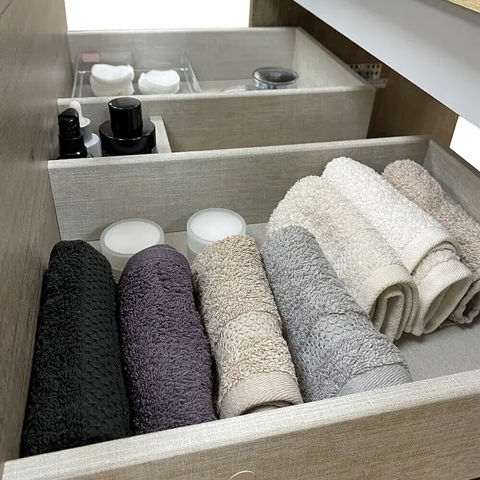Mueble bajo de lavabo Isa - An x Pr x Al: 60 x 44,6 x 54,5 cm, Verde, Apertura con uñero ingletado 45 grados - Cajón abierto con organizadores de madera clara, con toallas enrolladas de varios colores, discos de algodón y pequeños productos de belleza.